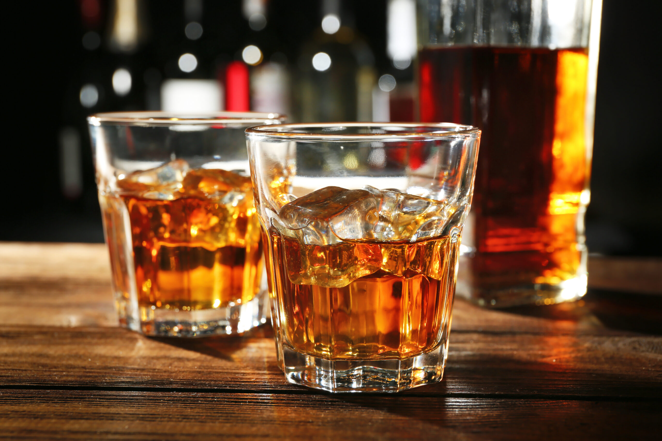 Glasses of whisky on wooden bar closeup