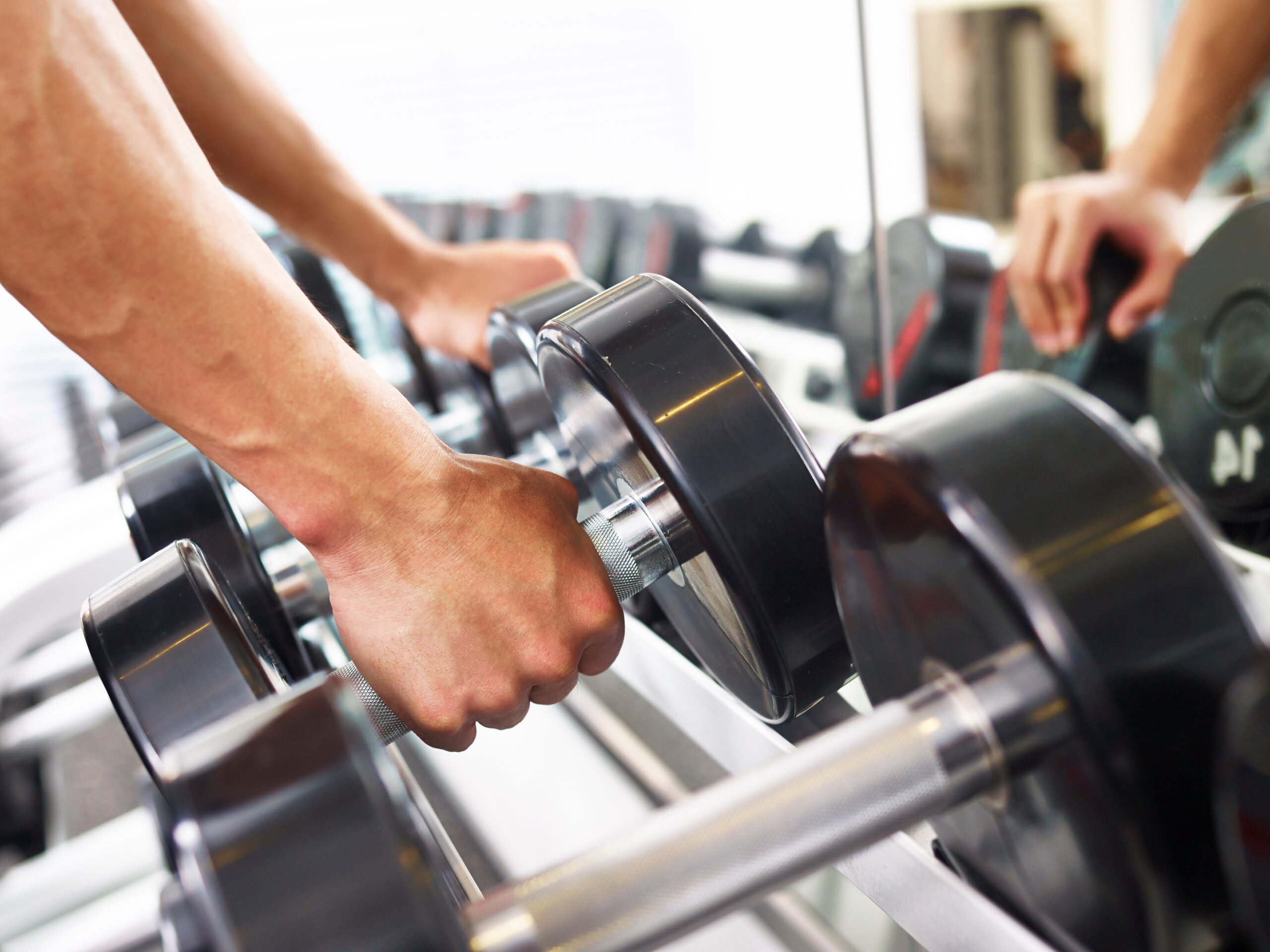 hand of a male lifting a dumbbell