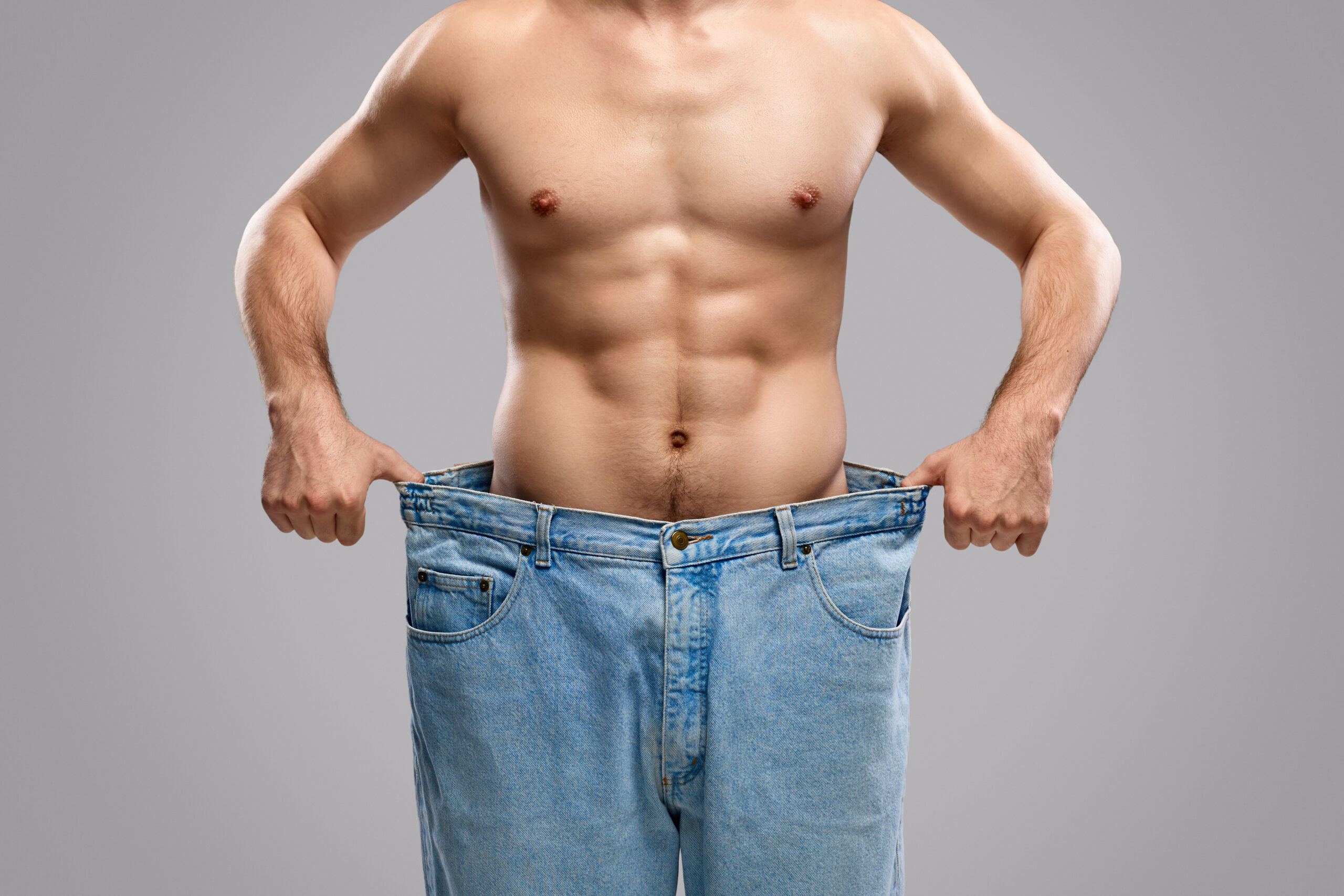 Crop man showing weight loss progress