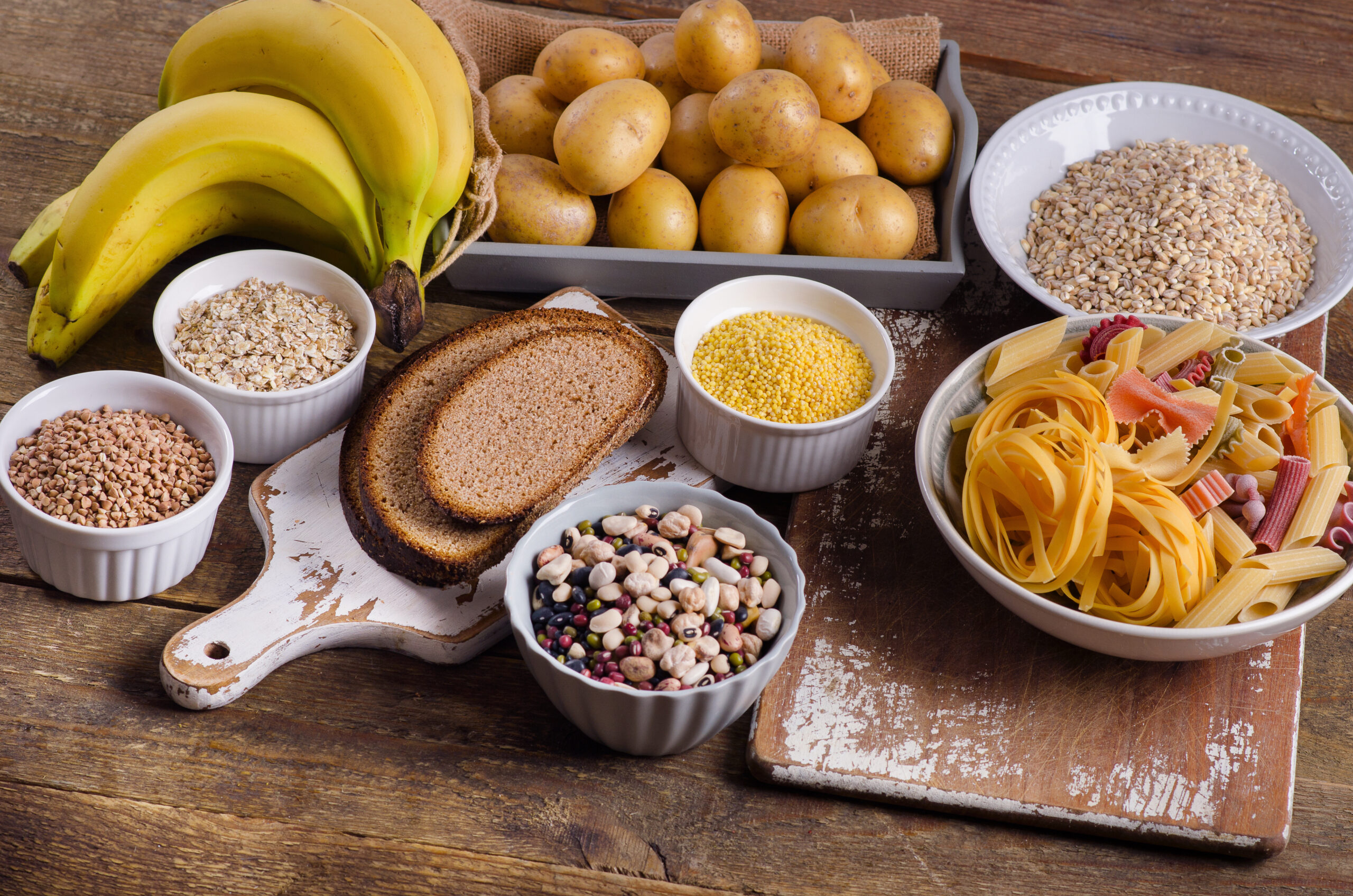 Foods high in carbohydrate on rustic wooden background.