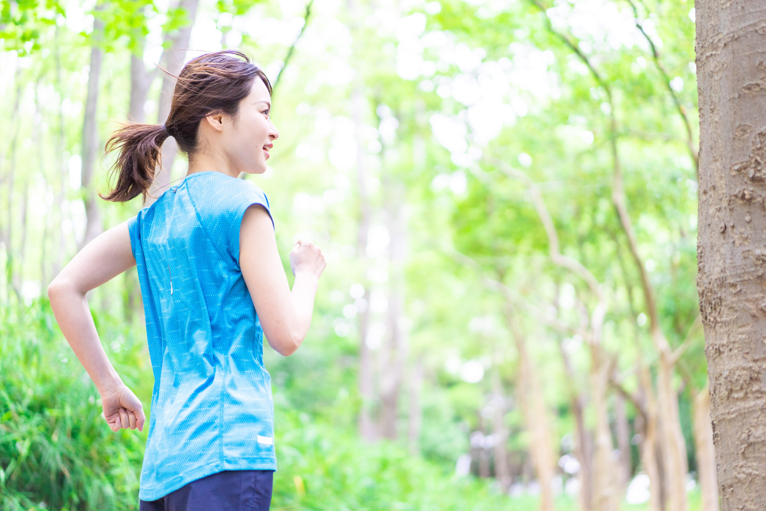 自然の中でランニングをする若い女性